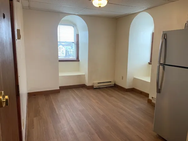 an empty room with wooden floor and a window