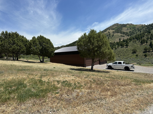 2006 Swenson Valley Road Bancroft, ID 83217 - Photo 23 of 51 Modern structure featuring a brown exterior, dark roof, and multiple garage doors