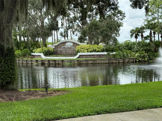 front view of house with a yard and palm trees
