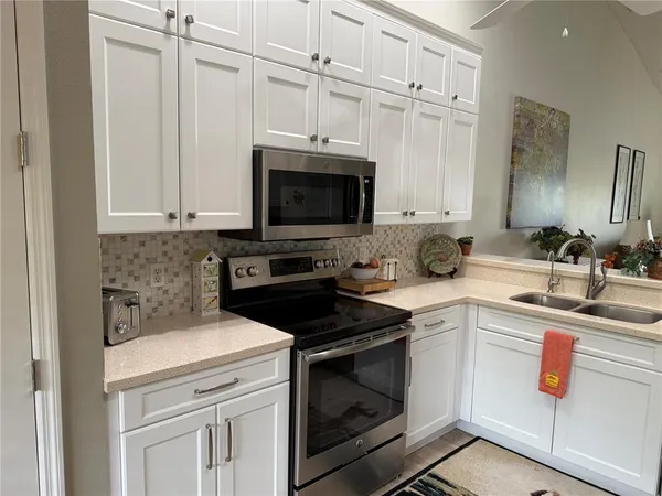 a kitchen with stainless steel appliances a refrigerator sink and cabinets