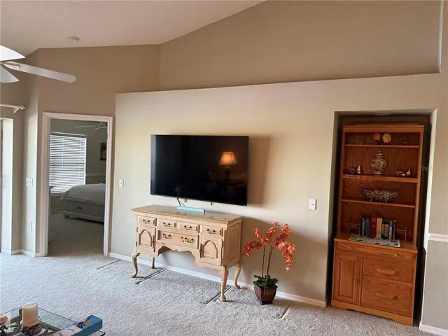 a bedroom with a bed and a chandelier fan