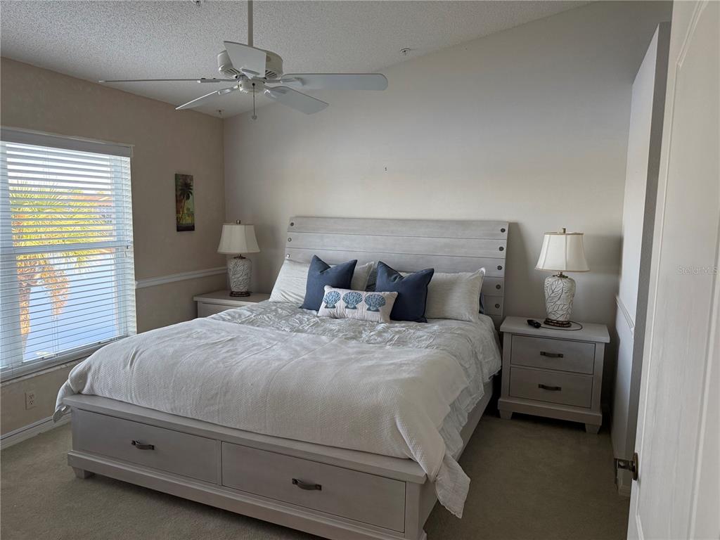 5251 Mahogany Run Avenue, Unit 524 Sarasota, FL 34241 - Photo 22 of 40 a bedroom with a bed and a chandelier