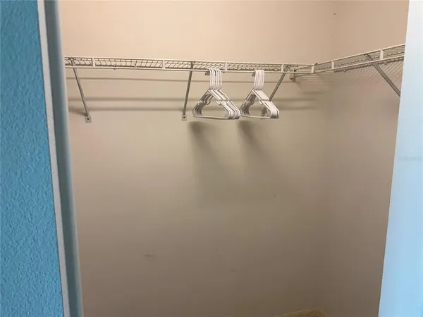 a bedroom with a bed and a lamp on the dresser