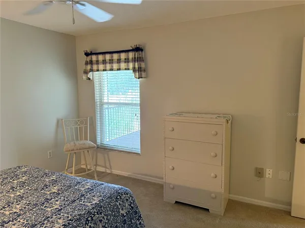 a bedroom with a bed and a chandelier fan