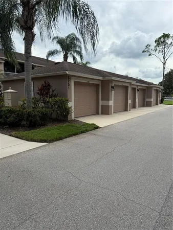front view of house with a yard and palm trees