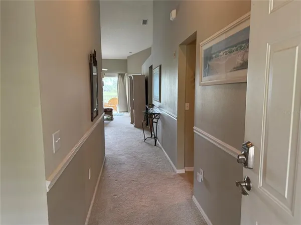 a view of a hallway with furniture and front door