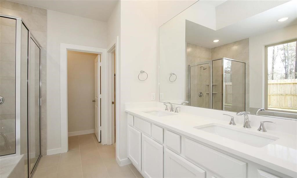 21582 Jordan Pond Ridge Porter, TX 77365 - Photo 14 of 21 a bathroom with double vanity sinks and a mirror