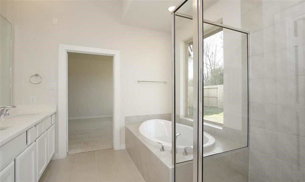 21582 Jordan Pond Ridge Porter, TX 77365 - Photo 16 of 21 a bathroom with a granite countertop sink a mirror and shower