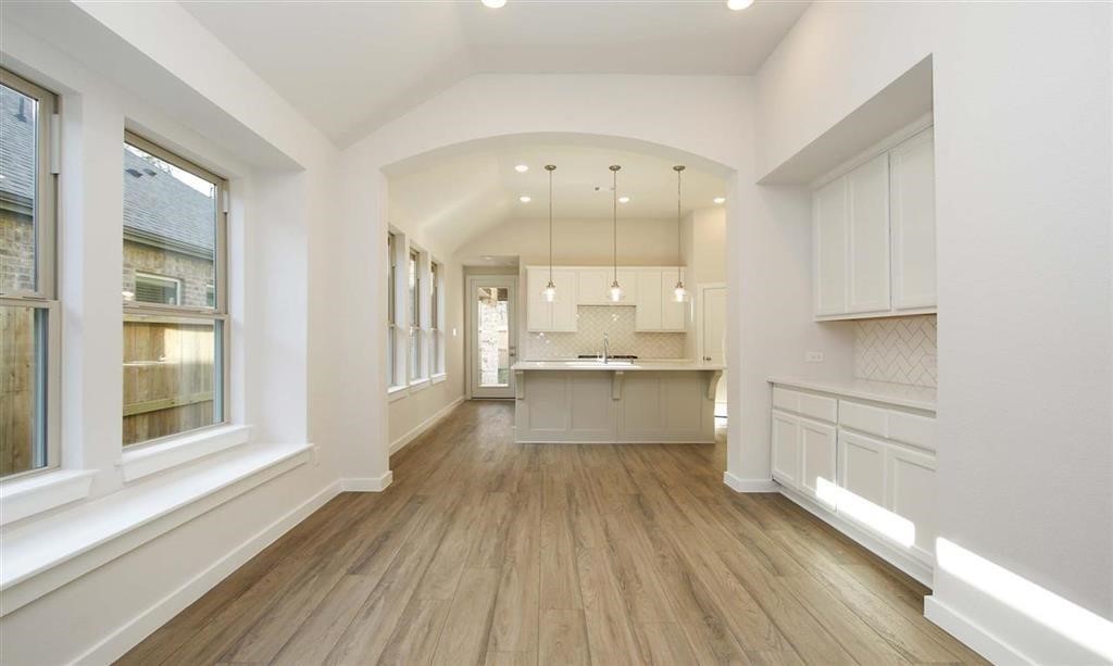 21582 Jordan Pond Ridge Porter, TX 77365 - Photo 19 of 21 a large white kitchen with kitchen island a large window appliances and cabinets