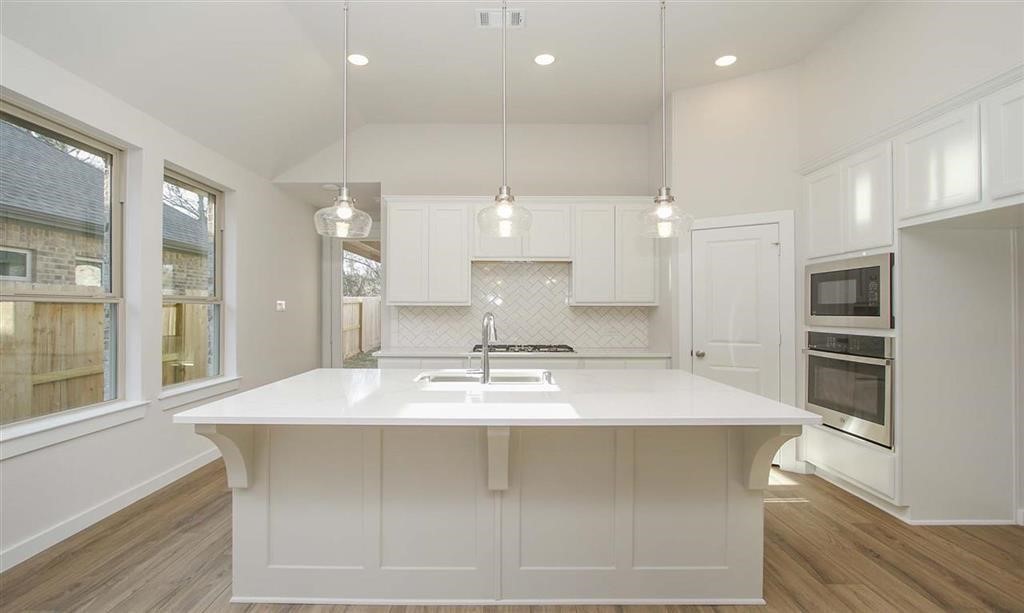 21582 Jordan Pond Ridge Porter, TX 77365 - Photo 2 of 21 a large kitchen with kitchen island a sink stainless steel appliances and cabinets