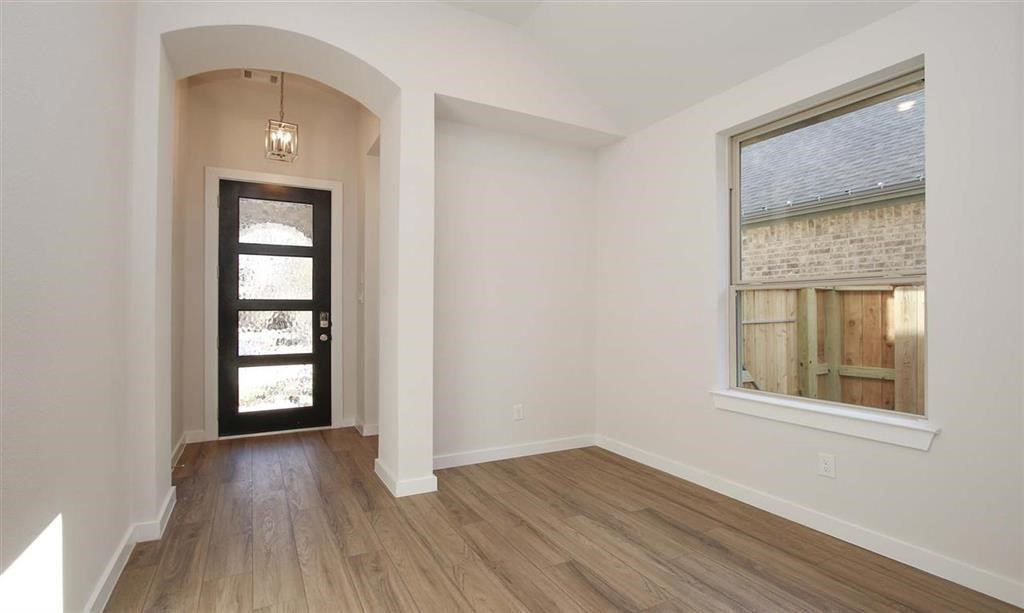 21582 Jordan Pond Ridge Porter, TX 77365 - Photo 21 of 21 an empty room with wooden floor cabinet and windows
