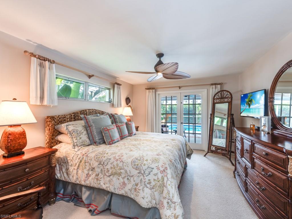 1820 Kingfish Road Naples, FL 34102 - Photo 14 of 20 a bedroom with a large bed and a large window