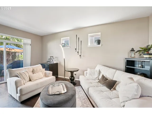 a living room with furniture white walls and a large window