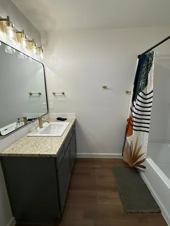 a bathroom with a granite countertop sink and a mirror