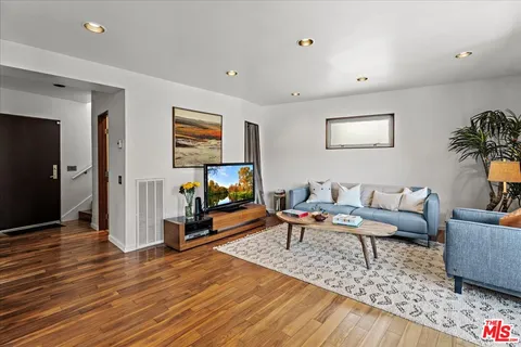 a living room with furniture and a wooden floor