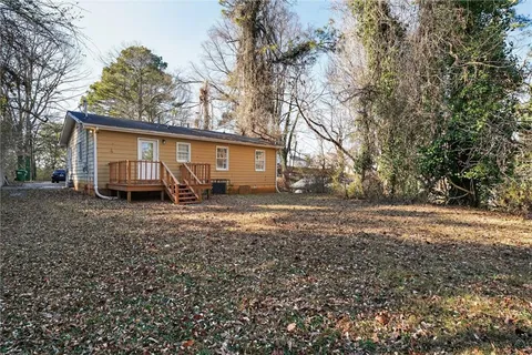 a view of a house with backyard and trees