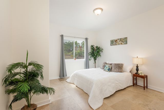 a bedroom with a large bed and a potted plant