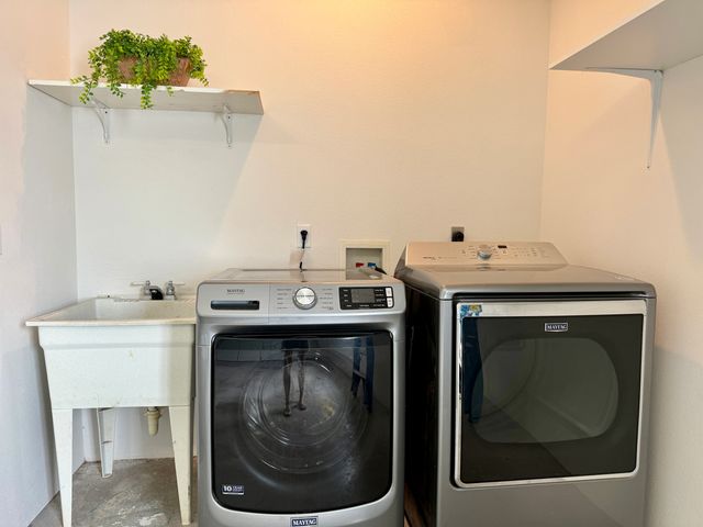 a utility room with a sink dryer and washer