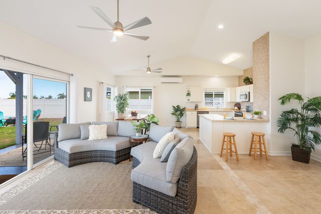 a living room with furniture kitchen view and a large window