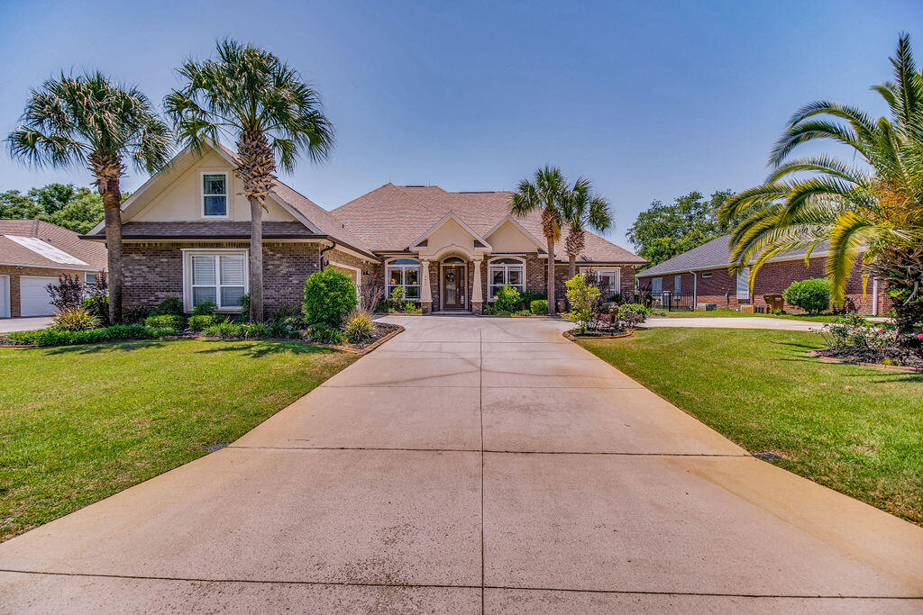 2655 Masters Boulevard Navarre, FL 32566 - Photo 1 of 87 a front view of a house with a garden and plants