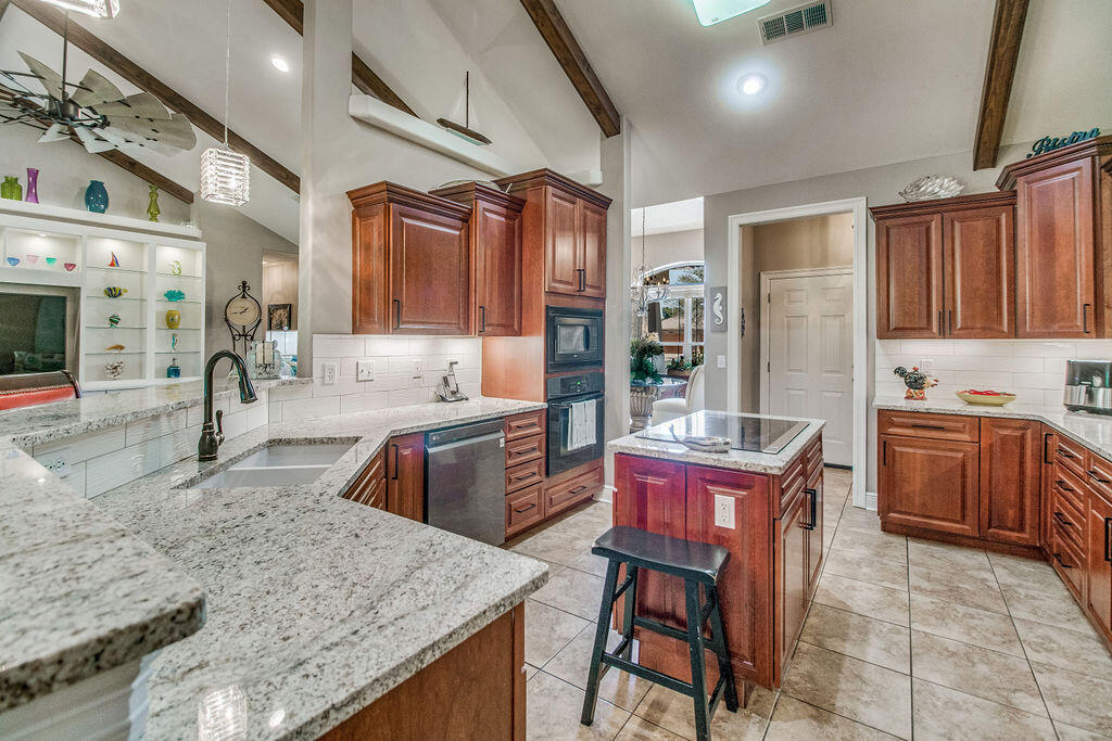 2655 Masters Boulevard Navarre, FL 32566 - Photo 14 of 87 a kitchen with stainless steel appliances granite countertop sink microwave and wooden cabinets