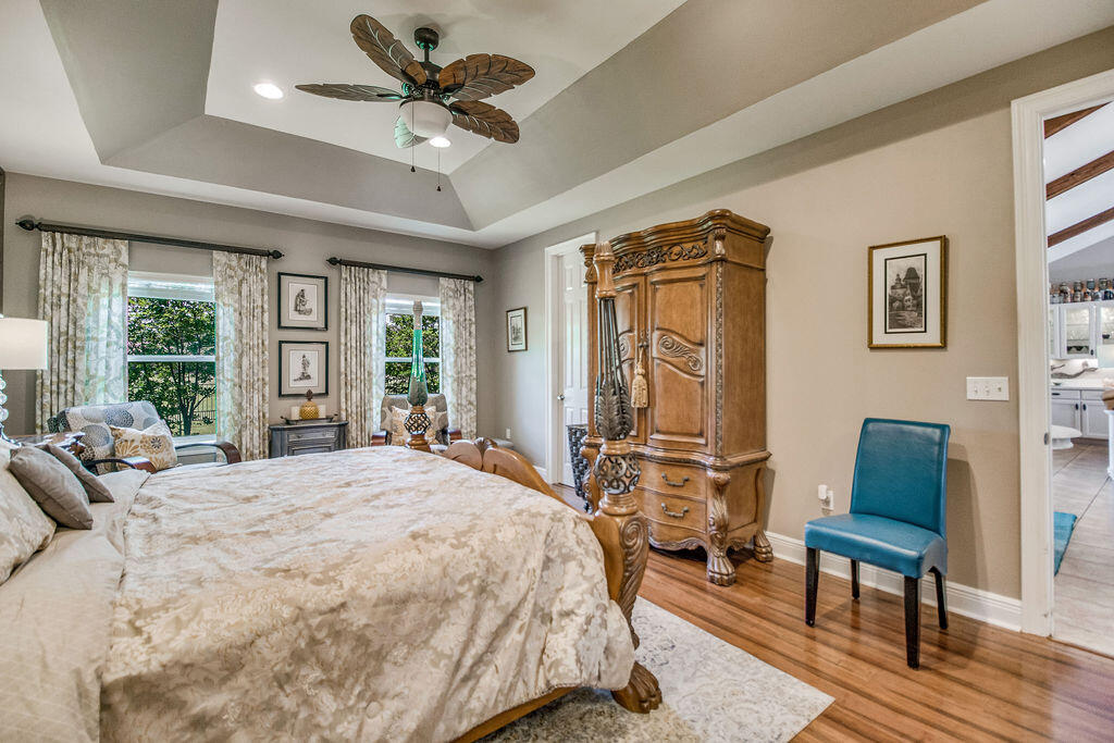 2655 Masters Boulevard Navarre, FL 32566 - Photo 22 of 87 a bedroom with a bed a couch and large window with wooden floor