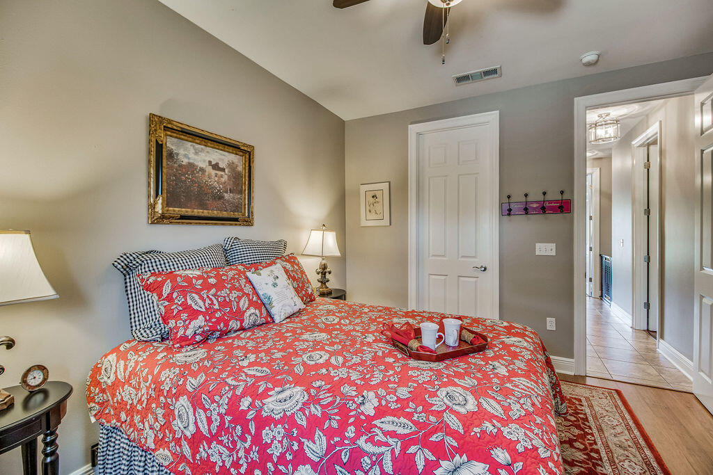 2655 Masters Boulevard Navarre, FL 32566 - Photo 38 of 87 a bedroom with a large bed and a chandelier