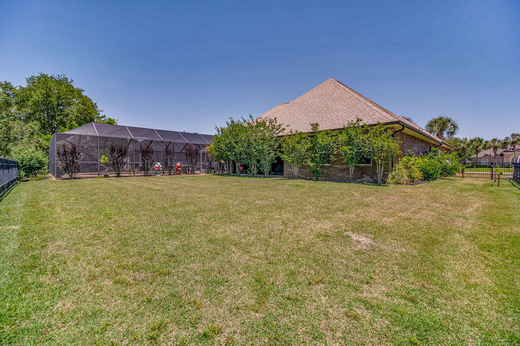 2655 Masters Boulevard Navarre, FL 32566 - Photo 56 of 87 a view of a house with a yard and a large tree