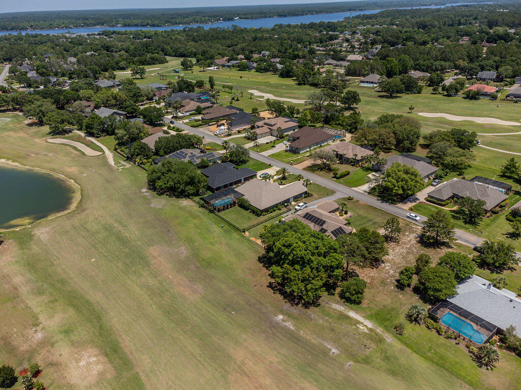 2655 Masters Boulevard Navarre, FL 32566 - Photo 68 of 87 an aerial view of residential houses with outdoor space and trees