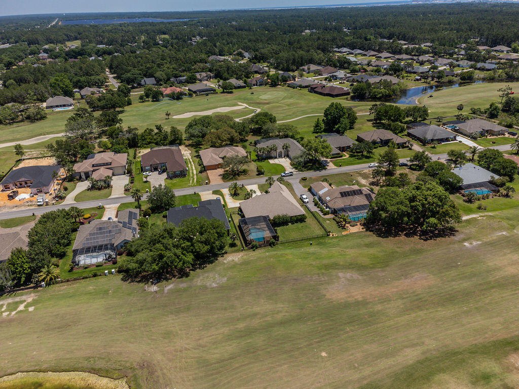 2655 Masters Boulevard Navarre, FL 32566 - Photo 86 of 87 an aerial view of residential houses with outdoor space and trees