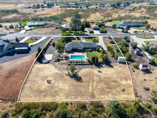 an aerial view of a house with a garden and chairs