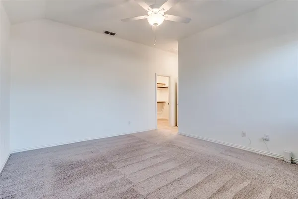 an empty room with a window and a ceiling fan