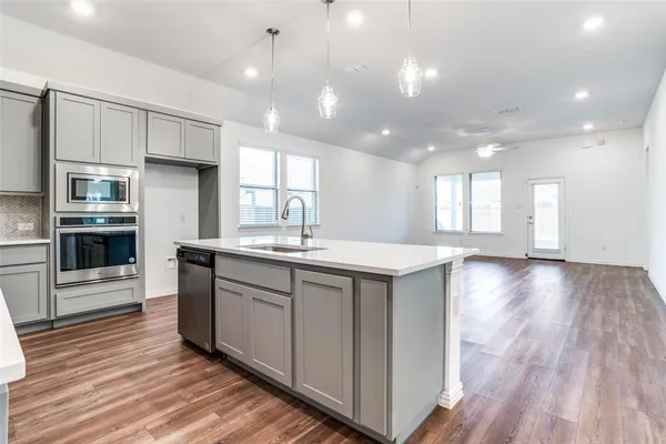 a kitchen with kitchen island a sink and a stove top oven