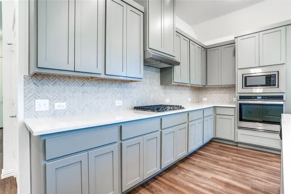 a kitchen with granite countertop white cabinets stainless steel appliances and a sink