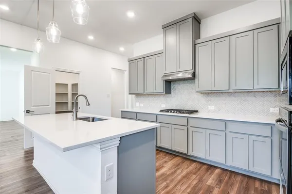 a kitchen that has a sink and a stove in it
