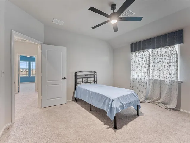 a bedroom with a large bed and a ceiling fan