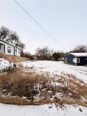 a view of a yard covered with snow in front of house