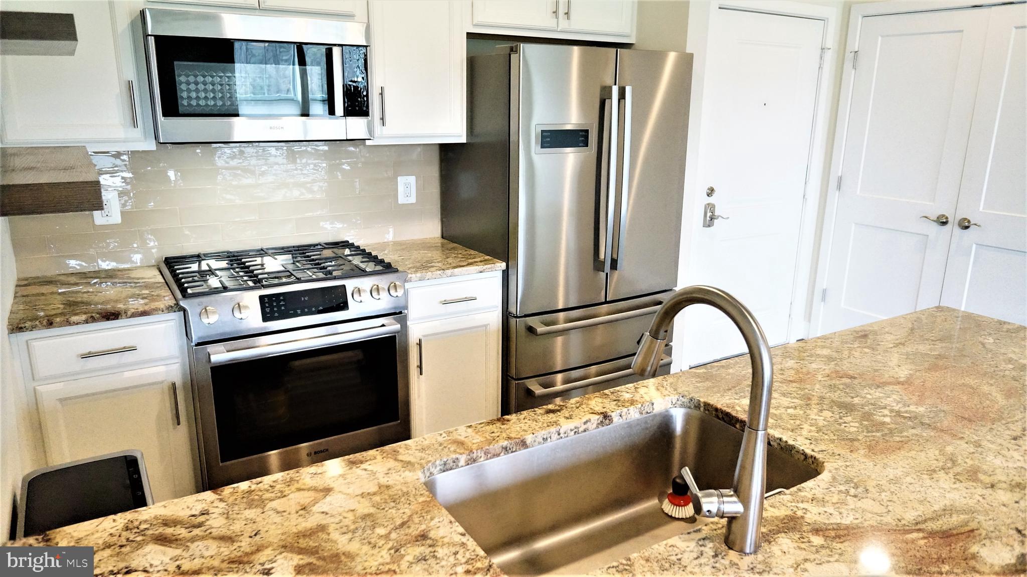 1951 Reston Vly Way, Unit 10 Reston, VA 20191 - Photo 9 of 50 a kitchen with stainless steel appliances kitchen island granite countertop a refrigerator stove top oven and sink