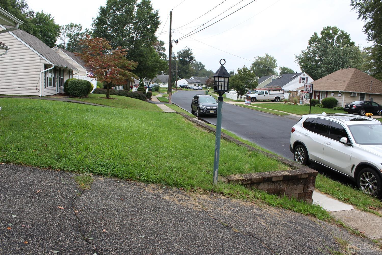 27 Markham Road Edison, NJ 08817 - Photo 26 of 28 a car parked in front of a house and a yard