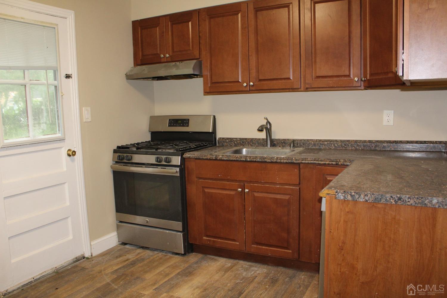 27 Markham Road Edison, NJ 08817 - Photo 3 of 28 a kitchen with granite countertop wooden cabinets and a stove top oven