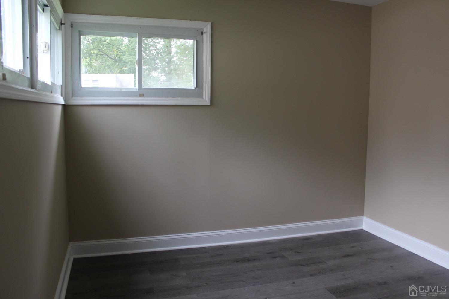 27 Markham Road Edison, NJ 08817 - Photo 7 of 28 a view of an empty room with wooden floor and a window