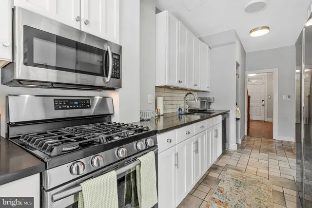 a kitchen with stainless steel appliances granite countertop a stove and a microwave