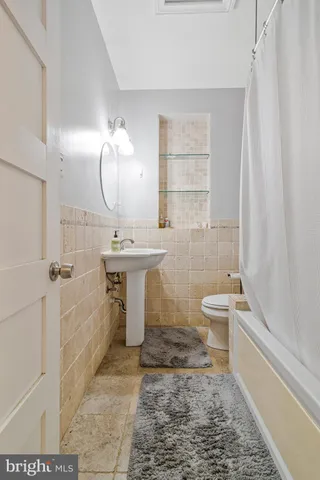 a bathroom with a sink a toilet and bathtub