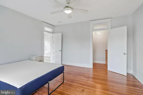 a spacious bedroom with a bed and a ceiling fan