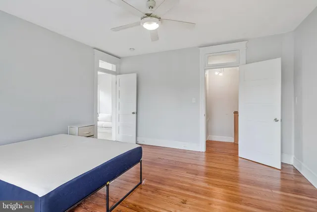 a spacious bedroom with a bed and a ceiling fan