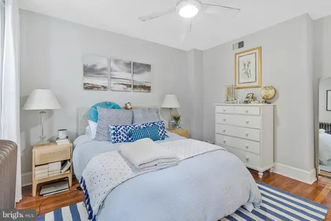 a bedroom with a bed and a lamp on dresser