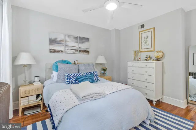 a bedroom with a bed and a lamp on dresser