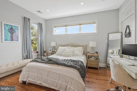 a bedroom with a bed and a flat tv screen on the dresser