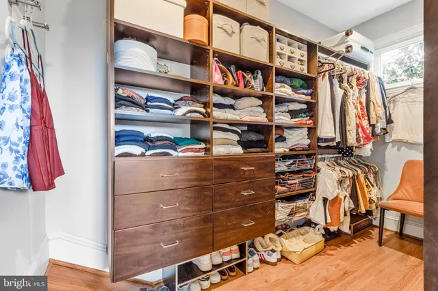 a view of walk in closet with clothes and shoes