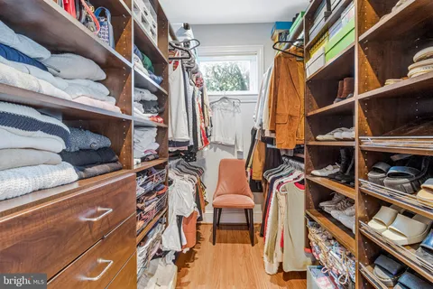 a view of walk in closet with clothes and shoes